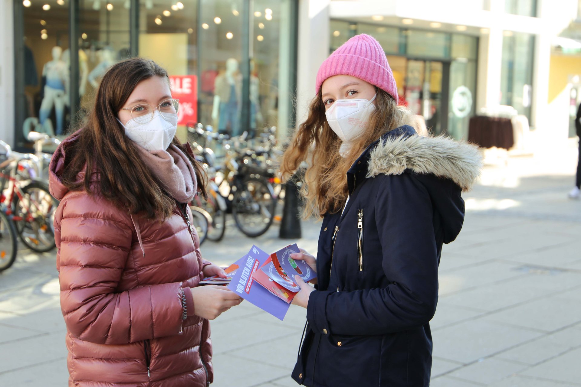 Junge Aktivistinnen verteilen Material zu Periodenarmut