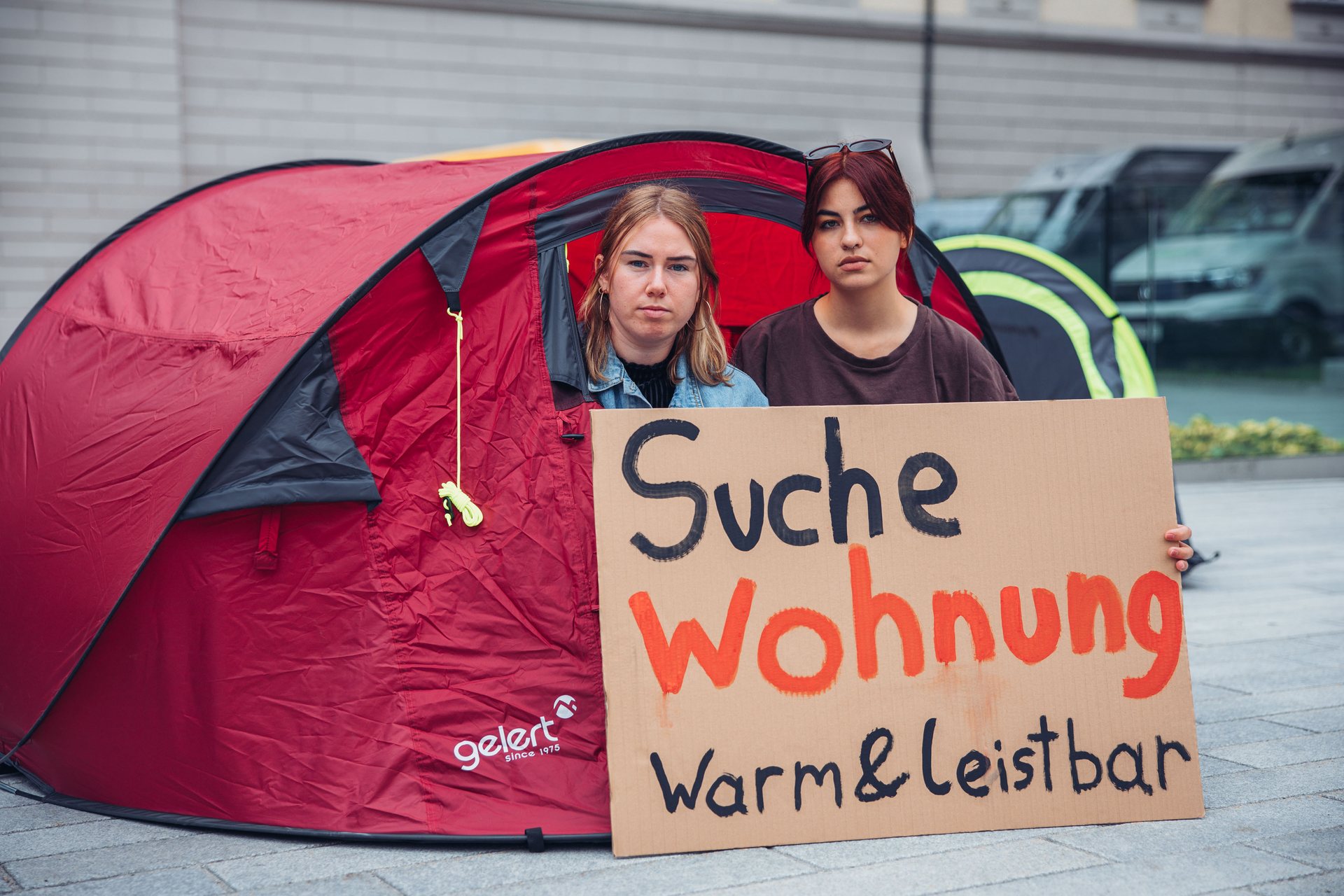 Jugendliche sitzen in einem Zelt und fordern leistbaren Wohnraum