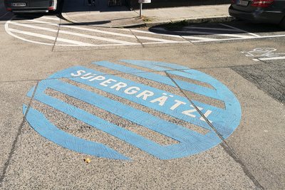 Große blaue Signets auf der Straße kennzeichnen den Beginn des Supergrätzels