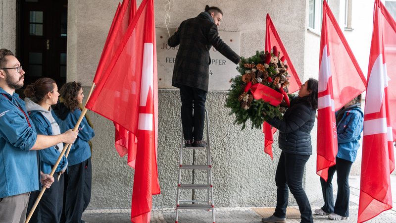 Bernhard Macek hängt den Gedenkkranz über die Gedenktafel für Josef Gerl. 
